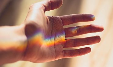 licht-an-hand Eine Hand mit farbigem Lichtreflex