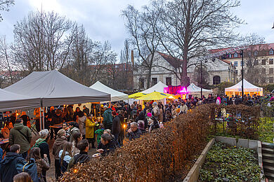 Stimmungsvoller Blick auf die Buden des veganen Weihnachtsmarkts in der beginnenden Dämmerung