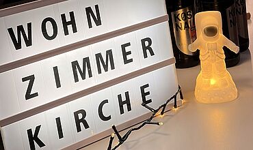 Buchstaben "Wohnzimmerkirche" auf einem Leuchtbord 