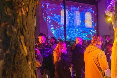Gäste vor der Lichtprojektion an der Kirchenwand