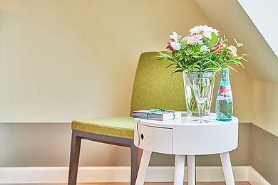 Stuhl, Tischchen und Blumen in einer Vase im Familienzimmer