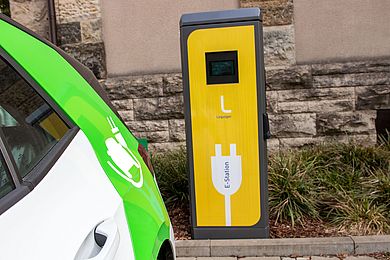 Ein Elektroauto steht vor einer gelben E-Station.