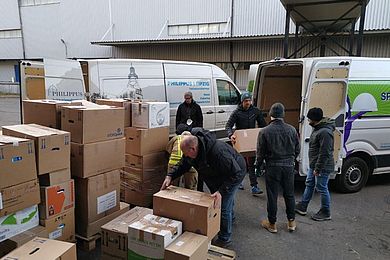 Sachspenden in Kartons werden für den Transport in Fahrzeuge der BBW-Leipzig-Gruppe gepackt