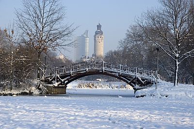 Leipzig City Park Winter Leipziger Johannapark im Schnee. Man sieht eine Brücke, dahinter das neue Rathaus und den MDR-Turm