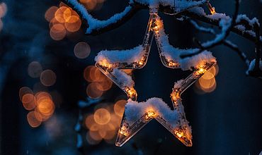 Sternenlichterkette an Tanne mit Schnee