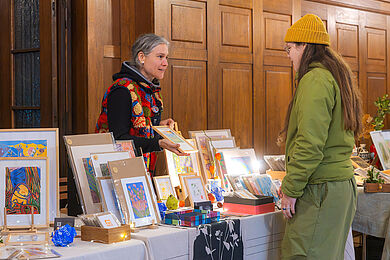 Stand mit gerahmten Bildern im historischen Saal